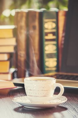 Kahve sabah işyerinde. bir kitap ya da dizüstü bilgisayar ile. seçici odak.