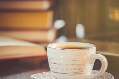 Kahve sabah işyerinde. bir kitap ya da dizüstü bilgisayar ile. seçici odak.