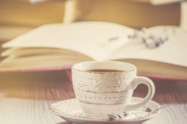 Kahve sabah işyerinde. bir kitap ya da dizüstü bilgisayar ile. seçici odak.