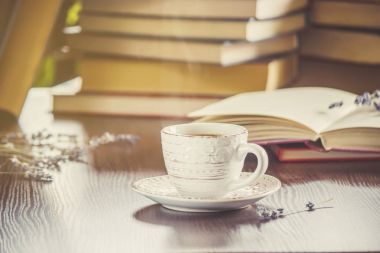 Kahve sabah işyerinde. bir kitap ya da dizüstü bilgisayar ile. seçici odak.