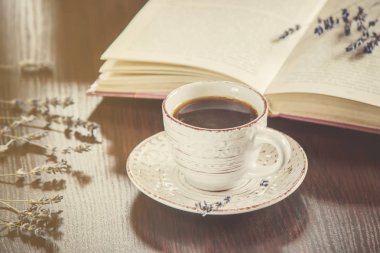 Kahve sabah işyerinde. bir kitap ya da dizüstü bilgisayar ile. seçici odak.