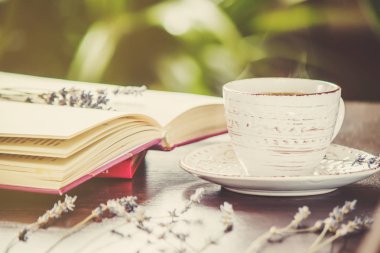 Kahve sabah işyerinde. bir kitap ya da dizüstü bilgisayar ile. seçici odak.