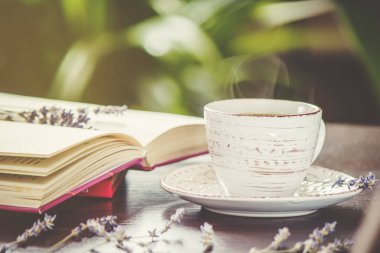 Kahve sabah işyerinde. bir kitap ya da dizüstü bilgisayar ile. seçici odak.