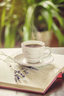 Kahve sabah işyerinde. bir kitap ya da dizüstü bilgisayar ile. seçici odak.