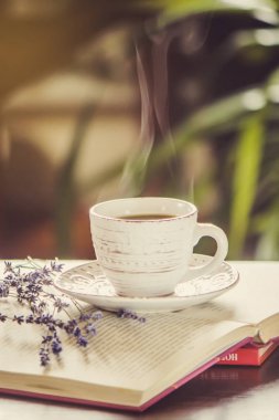 Kahve sabah işyerinde. bir kitap ya da dizüstü bilgisayar ile. seçici odak.