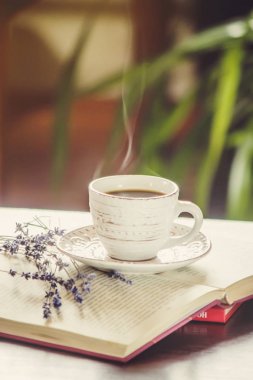 Kahve sabah işyerinde. bir kitap ya da dizüstü bilgisayar ile. seçici odak.