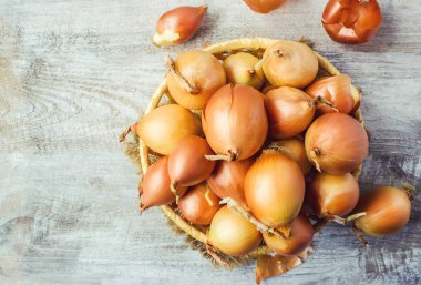 Ahşap zemin üzerine soğan orta boy sepet. seçici odak. 
