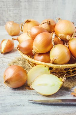 Ahşap zemin üzerine soğan orta boy sepet. seçici odak. 