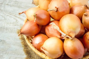 Ahşap zemin üzerine soğan orta boy sepet. seçici odak. 