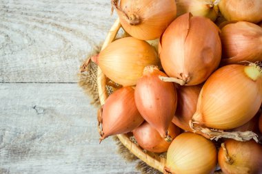 Ahşap zemin üzerine soğan orta boy sepet. seçici odak. 
