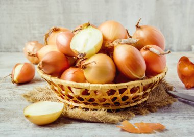 Ahşap zemin üzerine soğan orta boy sepet. seçici odak. 