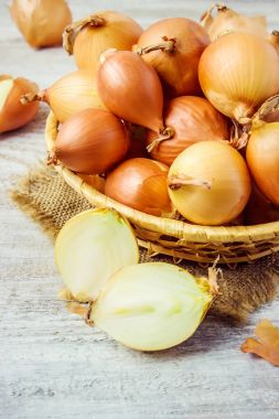 Ahşap zemin üzerine soğan orta boy sepet. seçici odak. 