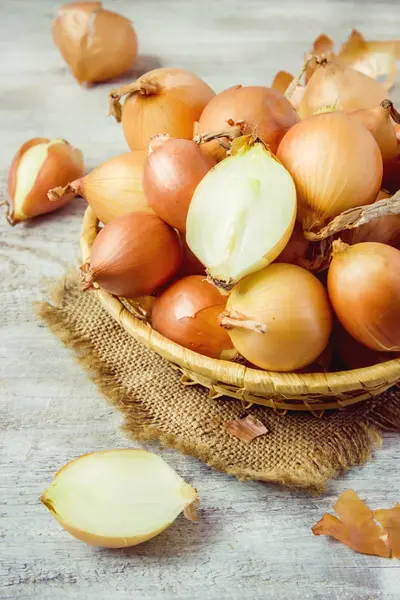 Basket of onion medium size on wooden background. selective focus. — Stock Photo, Image