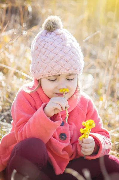 Flicka med våren gula blommor först. Selektivt fokus. — Stockfoto