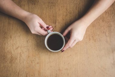 Bir fincan kahve kahvaltı onun elinde. Seçici odak. 