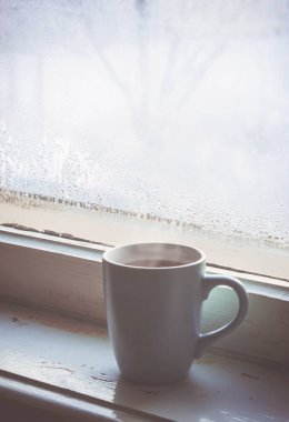 sıcak çay Kupası'nda pencere üzerinde. seçici odak. 
