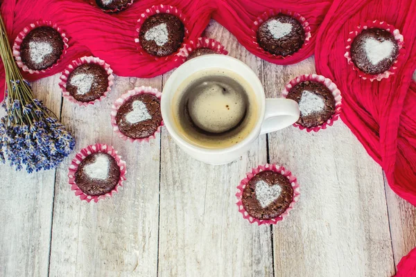 Kalpleri ve bir fincan kahve kahvaltı ile ev yapımı çikolata cupcakes. Seçici odak. Ahşap arka plan. — Stok fotoğraf