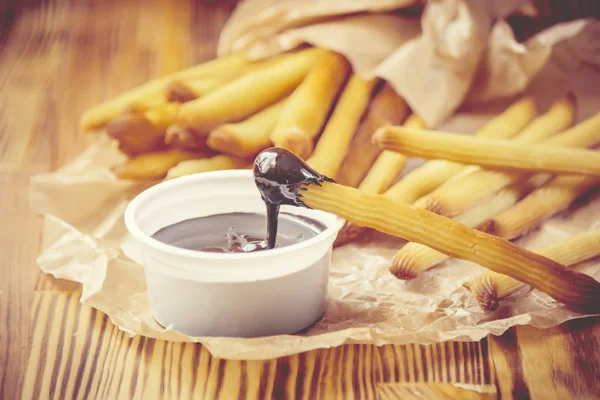 Churros tillagas i ugnen med choklad. Selektivt fokus. — Stockfoto