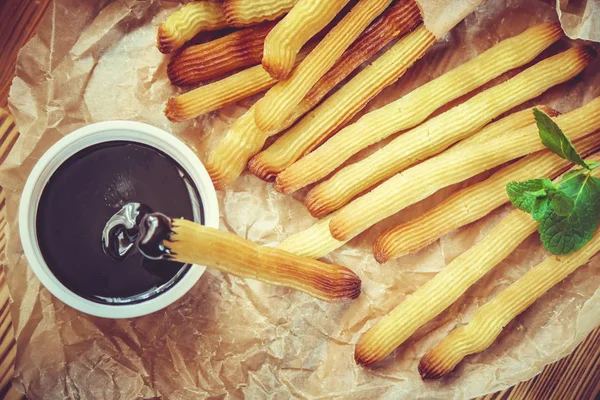 Churros tillagas i ugnen med choklad. Selektivt fokus. — Stockfoto