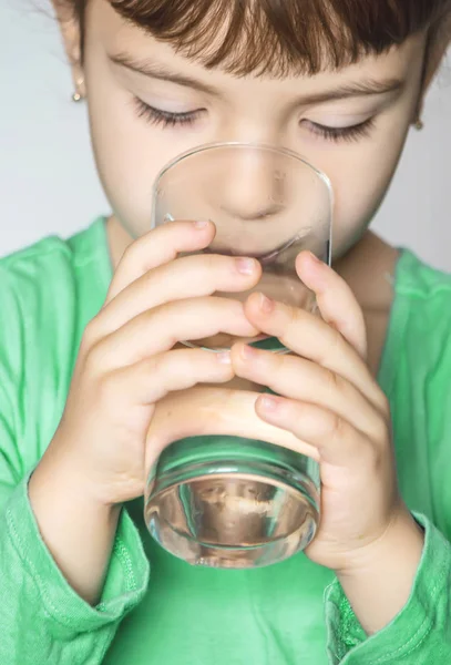 Dítě drží sklenku vody v jeho rukou. Selektivní fokus. — Stock fotografie