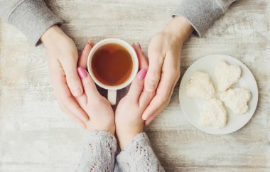 Aşıkların elinde kahvaltı için bir bardak içki. Seçici odak. 