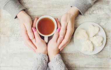 Aşıkların elinde kahvaltı için bir bardak içki. Seçici odak. 