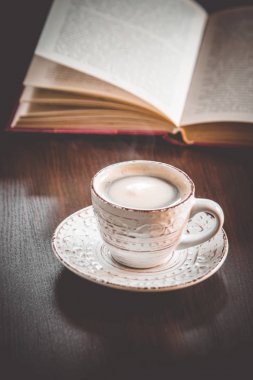 Kahve sabah işyerinde. bir kitap ya da dizüstü bilgisayar ile. seçici odak.