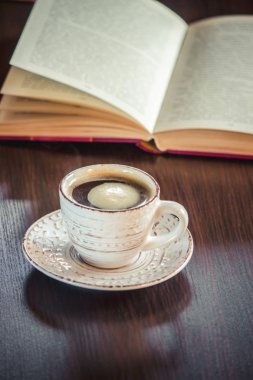 Kahve sabah işyerinde. bir kitap ya da dizüstü bilgisayar ile. seçici odak.