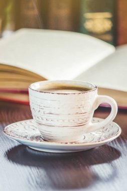 Kahve sabah işyerinde. bir kitap ya da dizüstü bilgisayar ile. seçici odak.