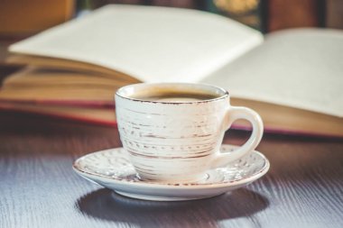 Kahve sabah işyerinde. bir kitap ya da dizüstü bilgisayar ile. seçici odak.