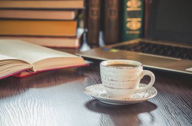 Kahve sabah işyerinde. bir kitap ya da dizüstü bilgisayar ile. seçici odak.