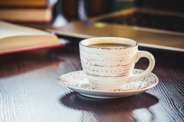 Kahve sabah işyerinde. bir kitap ya da dizüstü bilgisayar ile. seçici odak.