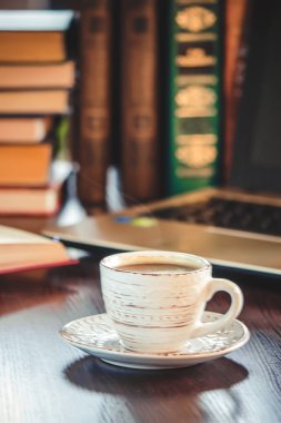 Kahve sabah işyerinde. bir kitap ya da dizüstü bilgisayar ile. seçici odak.