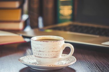 Kahve sabah işyerinde. bir kitap ya da dizüstü bilgisayar ile. seçici odak.