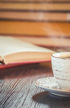 Kahve sabah işyerinde. bir kitap ya da dizüstü bilgisayar ile. seçici odak.
