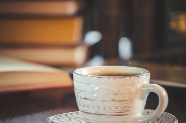 Kahve sabah işyerinde. bir kitap ya da dizüstü bilgisayar ile. seçici odak.