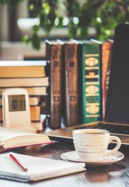 Kahve sabah işyerinde. bir kitap ya da dizüstü bilgisayar ile. seçici odak.