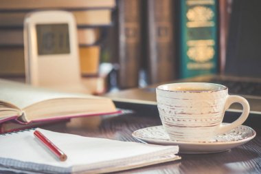 Kahve sabah işyerinde. bir kitap ya da dizüstü bilgisayar ile. seçici odak.