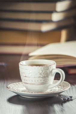 Kahve sabah işyerinde. bir kitap ya da dizüstü bilgisayar ile. seçici odak.
