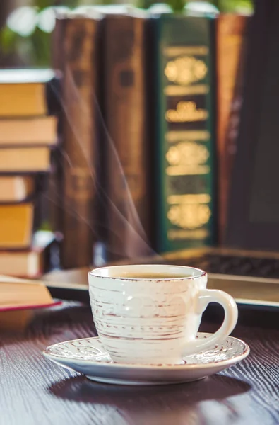 Café matinal sur le lieu de travail. avec un livre ou un portable. focus sélectif . — Photo