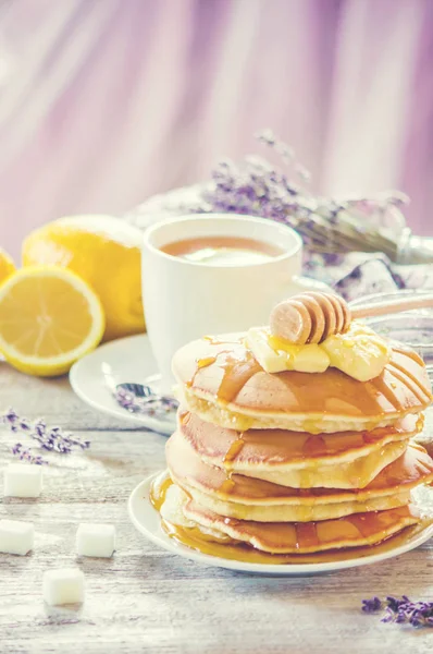 Pancakes with butter and honey and lemon tea for Breakfast. selective focus. — Stock Photo, Image