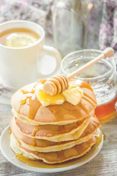 Tortitas con mantequilla y miel y té de limón para el desayuno. enfoque selectivo . — Foto de Stock