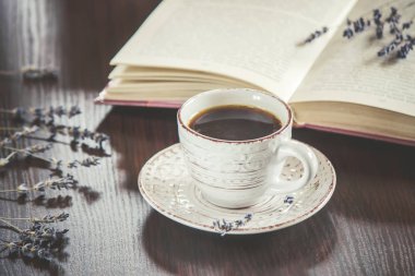 Fincan kahve ve boş bir kitap okuma sıcak. Seçici odak.
