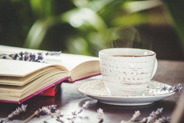 Fincan kahve ve boş bir kitap okuma sıcak. Seçici odak.