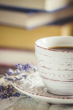 Fincan kahve ve boş bir kitap okuma sıcak. Seçici odak.