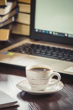 Kahve sabah işyerinde. bir kitap ya da dizüstü bilgisayar ile. seçici odak.