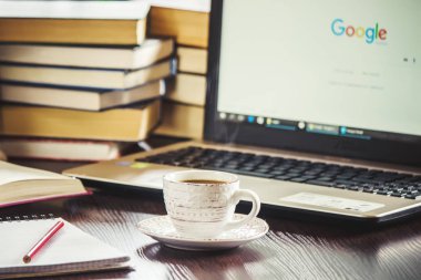 Kahve sabah işyerinde. bir kitap ya da dizüstü bilgisayar ile. seçici odak.