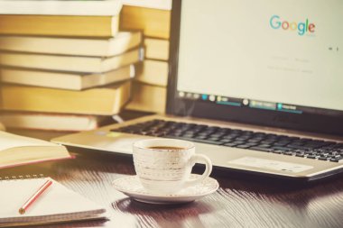 Kahve sabah işyerinde. bir kitap ya da dizüstü bilgisayar ile. seçici odak.