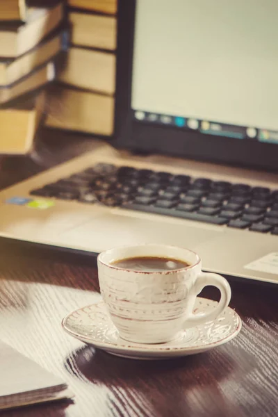 Poranna kawa w miejscu pracy. z książki lub laptopa. Selektywny fokus. — Zdjęcie stockowe