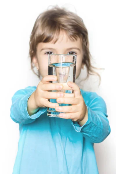 The child holds a glass of water in his hands. selective focus. Royalty Free Stock Images